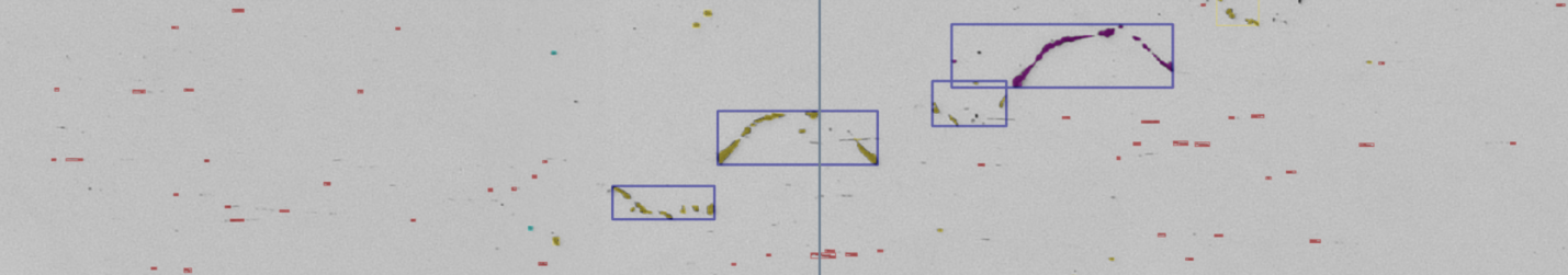 Grayscale field image with several boxed brown and purple curved inclusions aligned around a central vertical axis